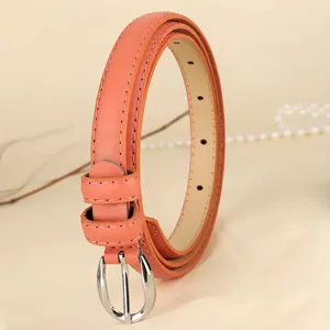 Close-up view of a coral leather belt with silver buckle and fine stitching