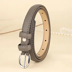 Detail view of a taupe thin leather belt with a silver oval buckle and fine stitching.