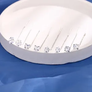 Detailopname van zilveren kwastjes oorbellen met hart- en ster-zirkonia hangers