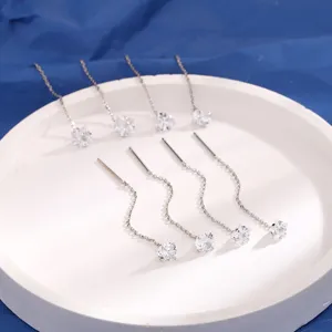 Detailweergave van zilveren kwastoorlijnen met geometrische zirkonia in ster- en hartvorm.
