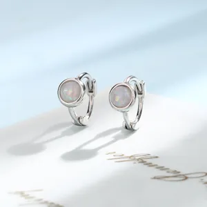 Detailed view of silver-tone huggie hoop earrings with iridescent round opal stones