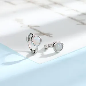 Detailed macro shot of minimalist silver hoop earrings featuring round white opal stones