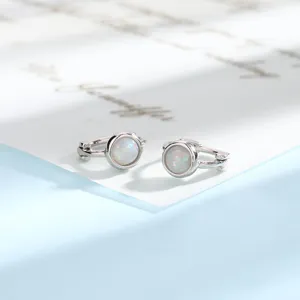 Detailed macro view of minimalist silver opal hoop earrings showing stone texture