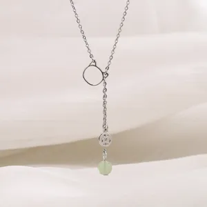 Dettaglio di un'elegante collana a orecchio di gatto con perla di giada e ciondolo