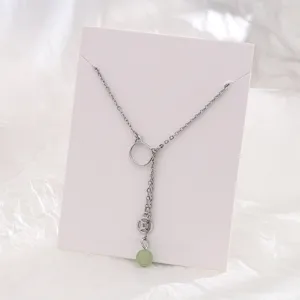 Vista dettagliata di una collana a gatto in argento con perla di giada verde e moneta