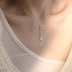 Elegante collana di gatto in giada Hetian con ciondolo a nappa in argento su una modella.