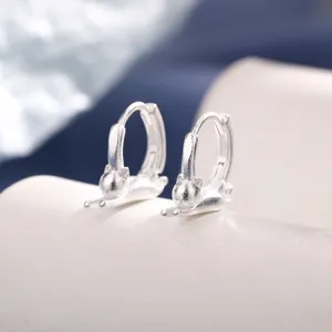 Close-up detail of matte silver cat hoop earrings with creative stretching kitten design