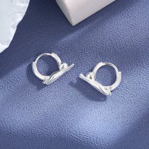 Macro view of silver cat-shaped hoop earrings with a brushed sand-surfaced finish