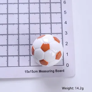Vista dettagliata del mini pallone da calcio in resina sulla griglia, peso 14,2 g.
