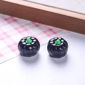 Détail macro de deux breloques citrouilles en résine noire brillante pour Halloween
