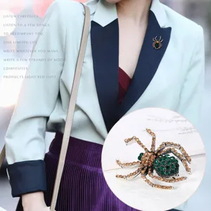 Detaillierte Nahaufnahme einer Vintage-Spinne-Brosche mit grünen und goldenen Strasssteinen