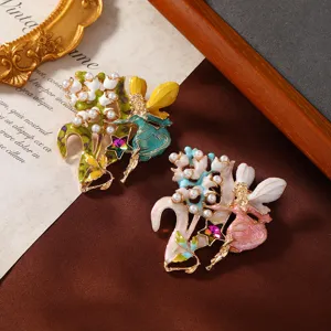 Detailed macro view of enamel fairy brooches with pearls and lily of the valley design.