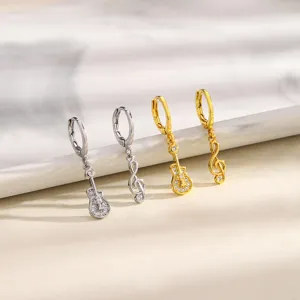 Detailed view of asymmetrical musical earrings with guitar and treble clef note designs.