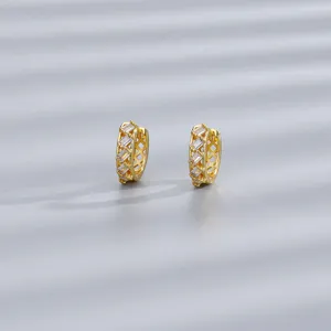 Dettaglio di orecchini a cerchio dorati con zirconi rettangolari e design traforato