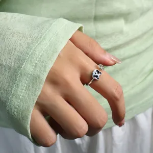 Macro detail of cute panda head and paw print adjustable silver open ring on finger