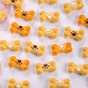 Macro view of cute bone-shaped biscuit resin charms with paw prints for DIY crafts