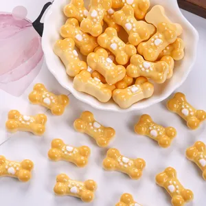 Macro view of cute yellow resin bone-shaped charms with white paw prints for DIY accessories