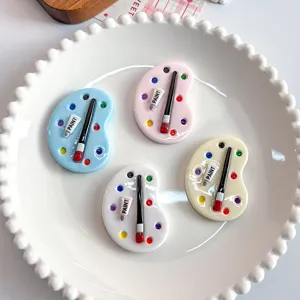 Detailed view of colorful miniature resin paint palettes with brushes on a white plate