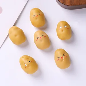 Vue détaillée de breloques mignonnes en résine en forme de patate avec divers visages