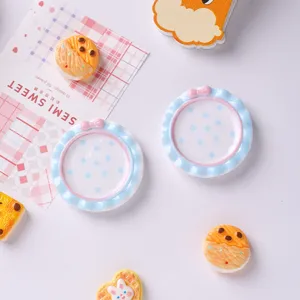 Vue détaillée de mini assiettes à pois bleus et nœuds roses pour maison de poupée