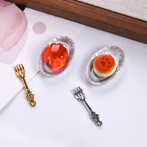 Detailed macro view of miniature dollhouse plates with fake food and vintage forks