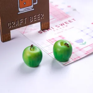 Detailed close-up of two miniature resin green apples for DIY dollhouse crafts decoration