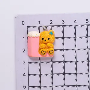 Detailed view of yellow resin bear charm on measurement grid showing small size