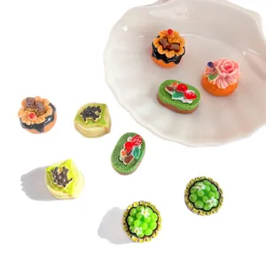 Gros plan de divers gâteaux miniatures colorés en résine pour décor de maison de poupée
