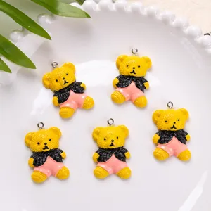 Detail view of five cute yellow resin teddy bear charms for DIY jewelry and crafts