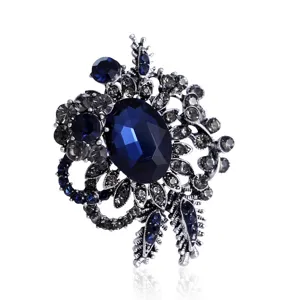 Macro view of vintage dark blue gemstone brooch with antique silver finish and crystals