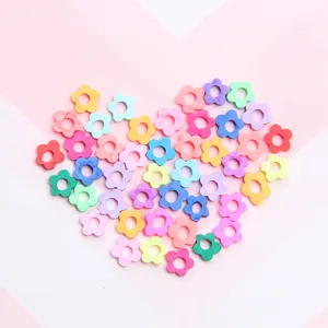 Nahaufnahme bunter blumenförmiger Fimo-Scheiben, als Herz angeordnet für DIY-Bastelarbeiten