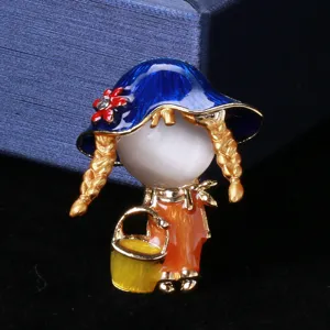 Close-up view of a cute Japanese style girl brooch featuring a blue hat and braids.
