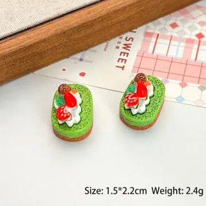Gros plan macro d'ornements de gâteau en résine miniature avec fraise et crème