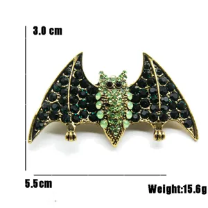 Detailed view of vintage bat brooch with green rhinestones showing 5.5cm width and 15.6g weight