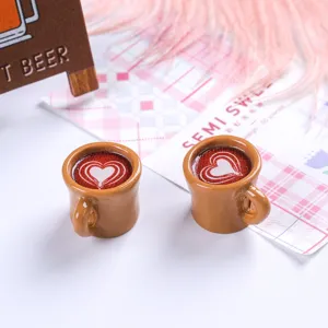 Close-up of miniature resin coffee cups with red heart latte art design for dollhouse