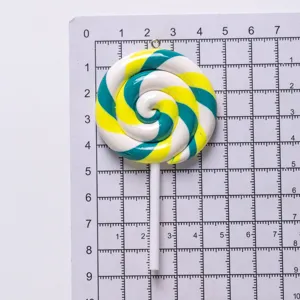 Detailed view of a large colorful polymer clay lollipop charm on a measurement grid