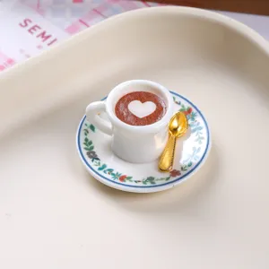Detailed view of a miniature resin coffee cup with heart latte art and a tiny gold spoon