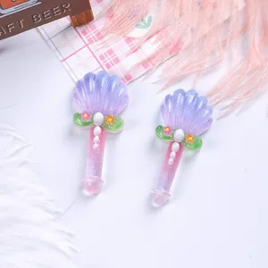 Detailed macro shot of glittery shell-topped magic wand resin charms for DIY jewelry