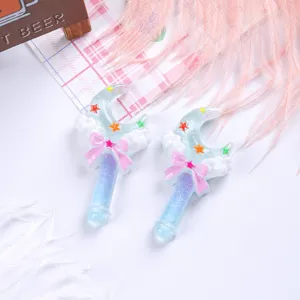 Detail showing two glittery moon-shaped magic wand resin accessories for DIY crafts