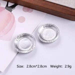 Macro view of two miniature silver dinner plates for dollhouse crafts and DIY projects