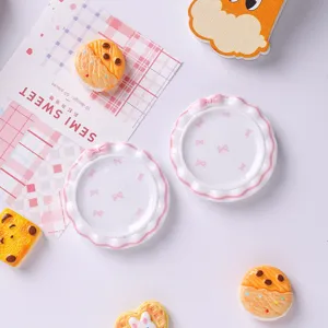 Vue macro détaillée de jolies assiettes de maison de poupée en résine avec nœud rose