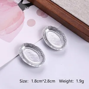 Close-up of miniature silver oval plates showing size and weight for dollhouse DIY