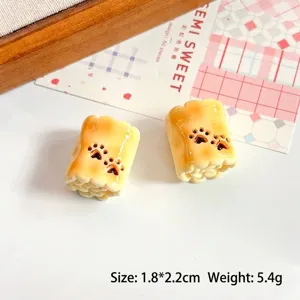Dettaglio di accessori in resina a forma di pane in miniatura con stampe di zampe