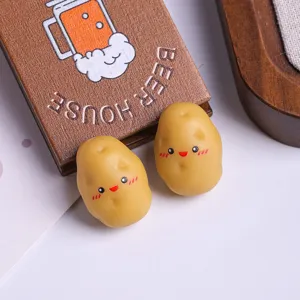 Gros plan de figurines miniatures de patates en résine avec d'adorables visages souriants