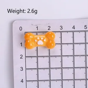 Cute orange resin bone charm with white paw print for DIY crafts and shoe decoration