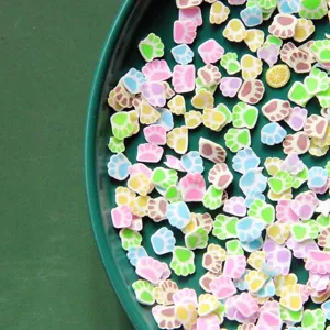 Close-up of colorful paw-shaped polymer clay slices for nail art decoration