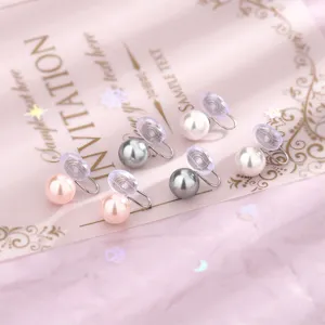 Dettaglio di orecchini a clip con perle rosa, grigie e bianche e chiusura a spirale morbida