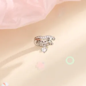 Primo piano di un ear cuff a corona a V con zirconi e pendente in finitura argento