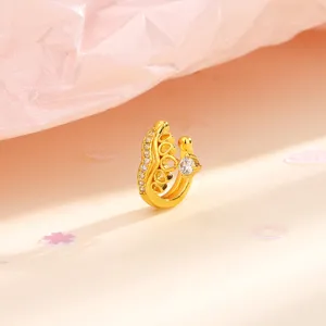 Macro di un orecchino ear cuff a corona dorata con zirconi brillanti