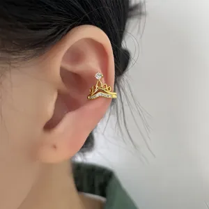 Primo piano di un ear cuff a corona dorato con zirconi sulla cartilagine
